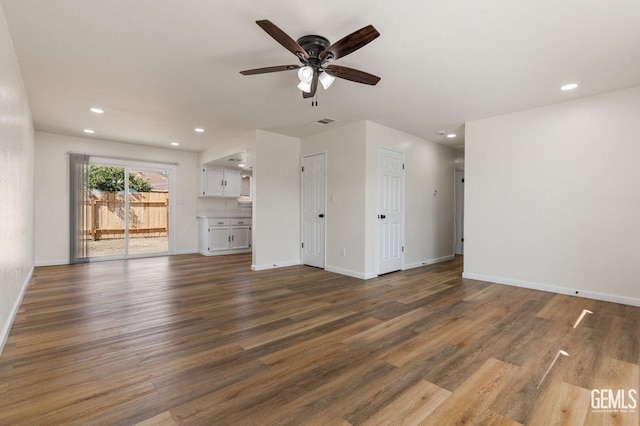 unfurnished living room featuring visible vents, baseboards, a ceiling fan, and wood finished floors