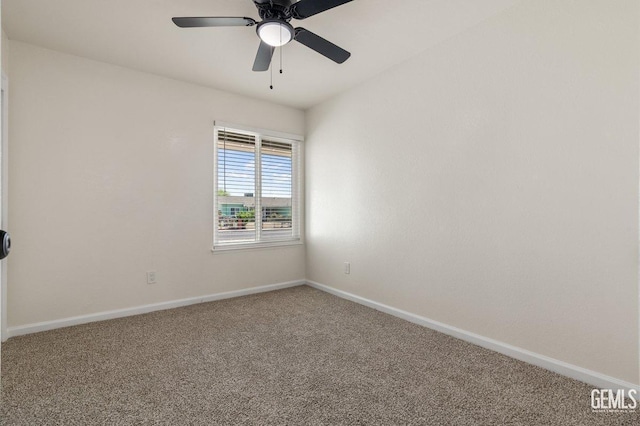 carpeted spare room with baseboards and ceiling fan