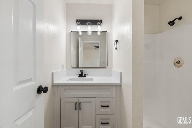 bathroom with walk in shower and vanity