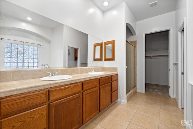 4207 Crystal Lake Dr, Bakersfield, CA 93313 - bathroom with a shower stall, double vanity, a spacious closet, tile patterned floors, and recessed lighting