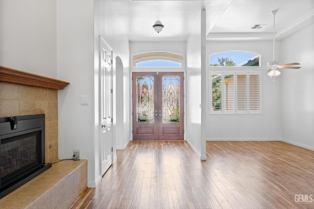 4207 Crystal Lake Dr, Bakersfield, CA 93313 - foyer entrance with wood finished floors, a fireplace, a ceiling fan, french doors, and arched walkways