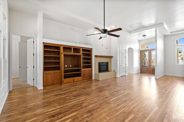 4207 Crystal Lake Dr, Bakersfield, CA 93313 - unfurnished living room featuring a towering ceiling, arched walkways, ceiling fan, wood finished floors, and a fireplace