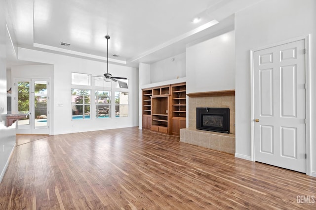 4207 Crystal Lake Dr, Bakersfield, CA 93313 - unfurnished living room with a raised ceiling, wood finished floors, a tiled fireplace, a ceiling fan, and a high ceiling