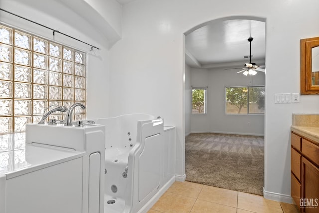 4207 Crystal Lake Dr, Bakersfield, CA 93313 - laundry room featuring light colored carpet, a ceiling fan, light tile patterned floors, and arched walkways