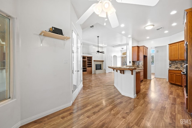 4207 Crystal Lake Dr, Bakersfield, CA 93313 - kitchen featuring ceiling fan, open floor plan, backsplash, a kitchen breakfast bar, and a peninsula