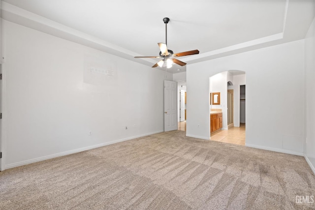 4207 Crystal Lake Dr, Bakersfield, CA 93313 - spare room featuring light colored carpet, ceiling fan, arched walkways, and a tray ceiling