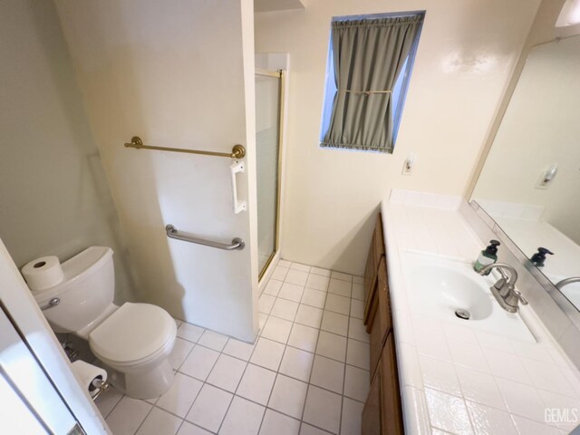 bathroom featuring tile patterned flooring, vanity, an enclosed shower, and toilet