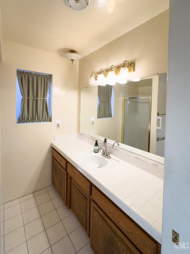 bathroom featuring vanity, a shower with door, and tile patterned floors