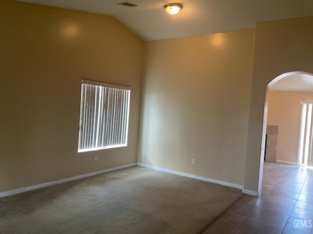 spare room with carpet and lofted ceiling