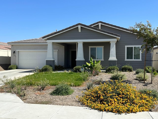 7410 Koyuk River St, Bakersfield, CA 93311 - view of front of property featuring a garage, concrete driveway, a tile roof, and covered porch