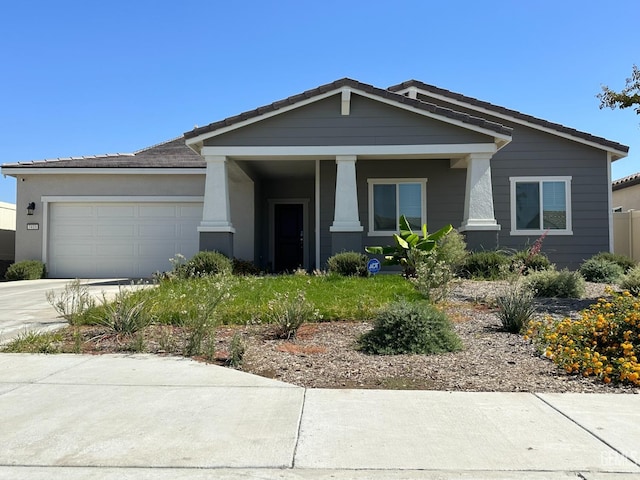 7410 Koyuk River St, Bakersfield, CA 93311 - view of front of home featuring a garage, concrete driveway, covered porch, a tile roof, and stucco siding