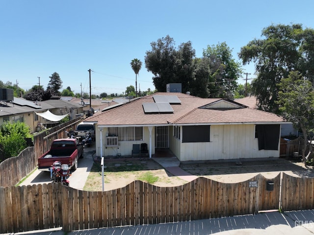 1004 Paloma St, Bakersfield, CA 93304 - view of front facade featuring a shingled roof, a fenced front yard, and solar panels