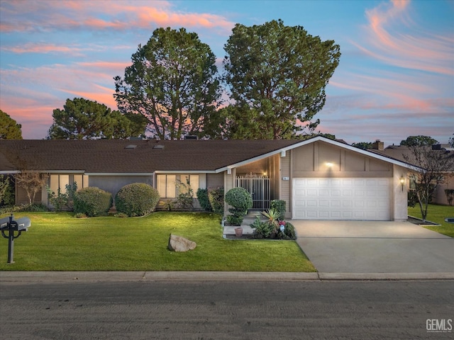 ranch-style house featuring a garage and a lawn