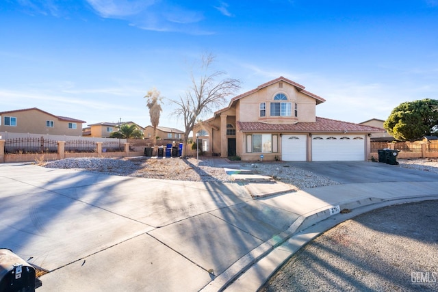 view of front of home featuring concrete driveway, a tile roof, fence, and stucco siding