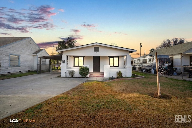 view of front of property featuring a carport, a yard, and a porch