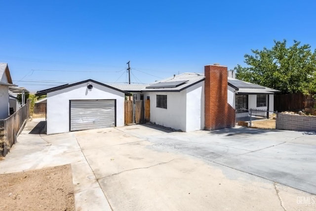 ranch-style house with an outbuilding, a garage, and solar panels