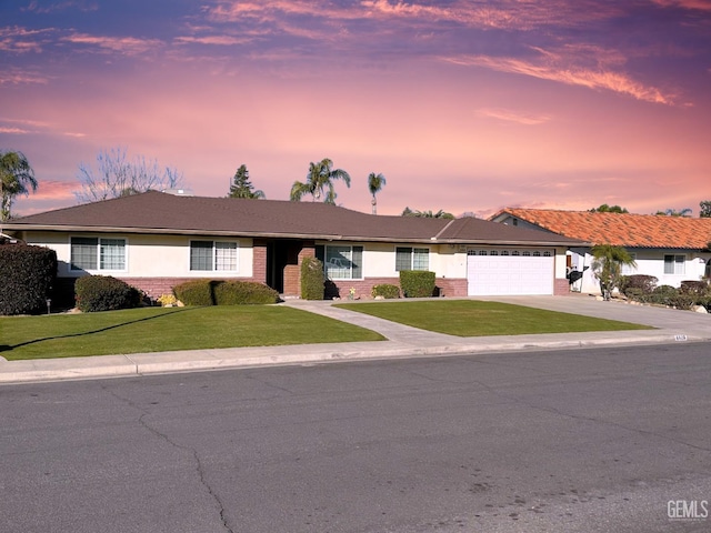 ranch-style home featuring a garage and a yard