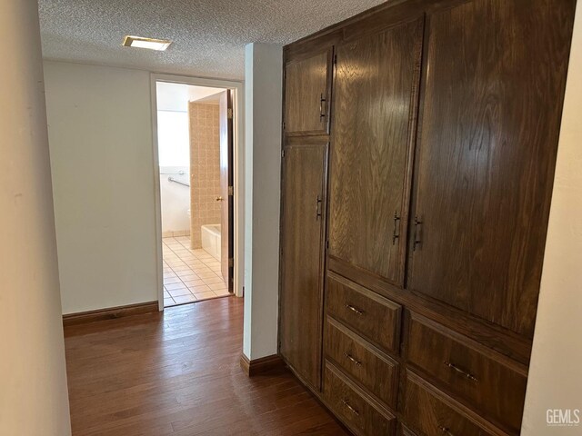 hallway featuring a textured ceiling and wood-type flooring