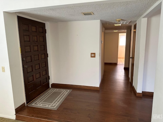 entryway featuring dark hardwood / wood-style flooring and a textured ceiling