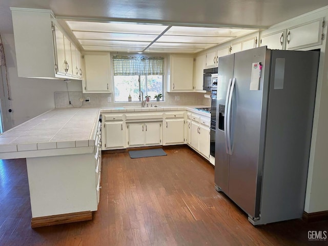 kitchen with sink, backsplash, white cabinetry, stainless steel fridge with ice dispenser, and dark hardwood / wood-style floors