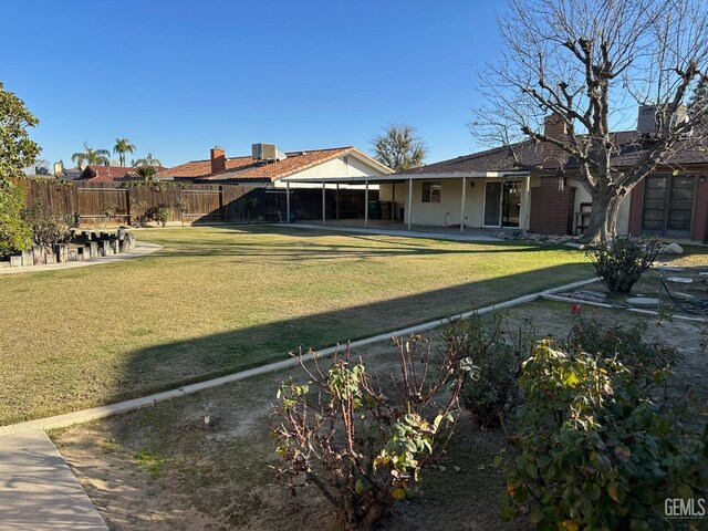 back of house featuring a lawn and a patio