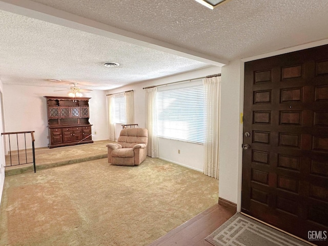 unfurnished living room with ceiling fan with notable chandelier, a textured ceiling, and dark hardwood / wood-style flooring