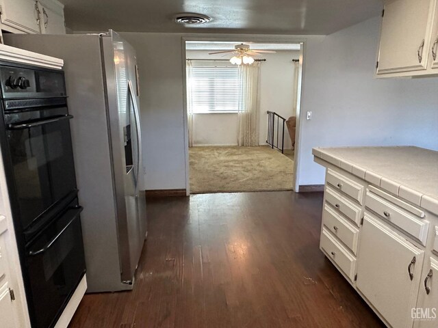 kitchen with tile countertops, black appliances, decorative backsplash, white cabinetry, and dark wood-type flooring