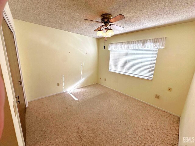 empty room featuring ceiling fan, hardwood / wood-style floors, a textured ceiling, and french doors