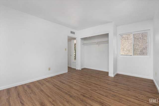 unfurnished bedroom featuring a closet and dark hardwood / wood-style flooring