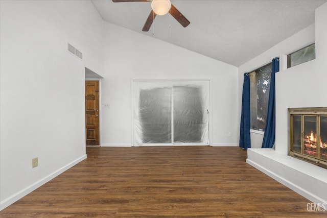 unfurnished living room featuring ceiling fan, dark hardwood / wood-style flooring, and vaulted ceiling