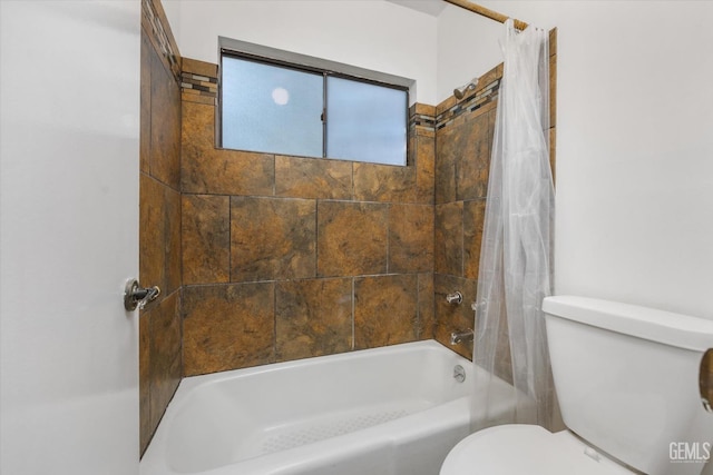 bathroom featuring shower / bath combination with curtain and toilet