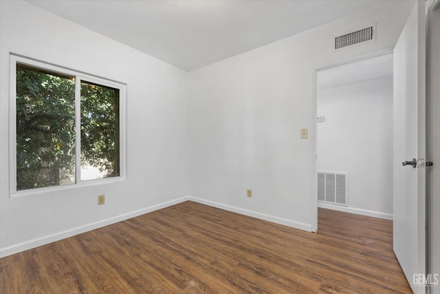 unfurnished room with a wealth of natural light and dark wood-type flooring