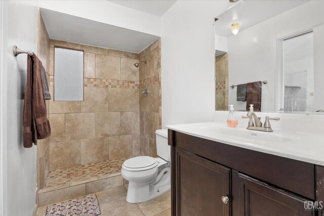 bathroom featuring vanity, toilet, and tiled shower