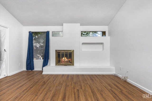 unfurnished living room with wood-type flooring, a textured ceiling, and vaulted ceiling