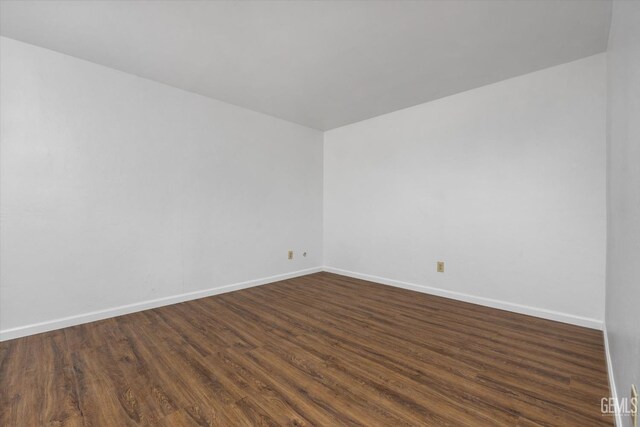 unfurnished room with dark hardwood / wood-style flooring