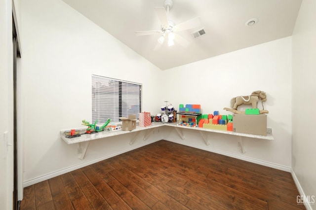 interior space with visible vents, a ceiling fan, vaulted ceiling, baseboards, and dark wood finished floors