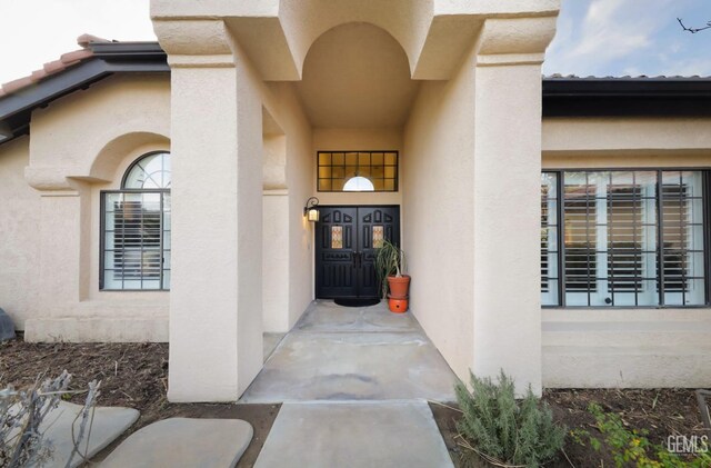 doorway to property featuring stucco siding