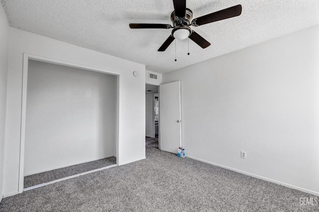 unfurnished bedroom featuring carpet, visible vents, ceiling fan, a textured ceiling, and baseboards