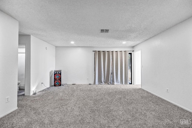 carpeted empty room featuring a textured ceiling, visible vents, and recessed lighting