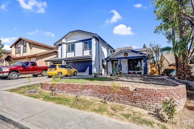 view of front of house with a garage, concrete driveway, and stucco siding