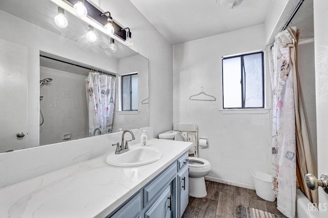 full bathroom with shower / bath combination with curtain, toilet, vanity, wood finished floors, and baseboards