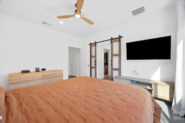 unfurnished bedroom featuring ceiling fan and a barn door