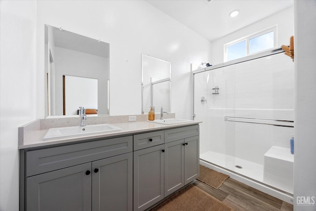 bathroom with hardwood / wood-style flooring, walk in shower, and vanity