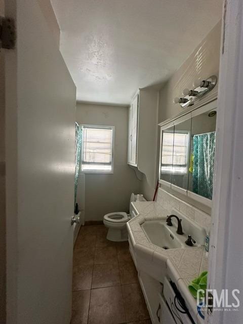 bathroom with tile patterned flooring, vanity, and toilet