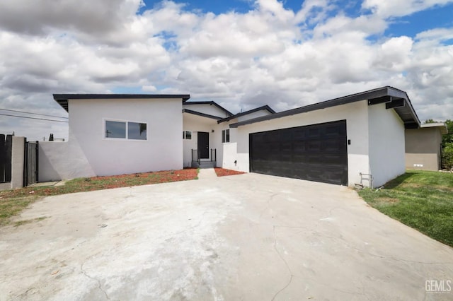 view of front of property with stucco siding, concrete driveway, and a garage