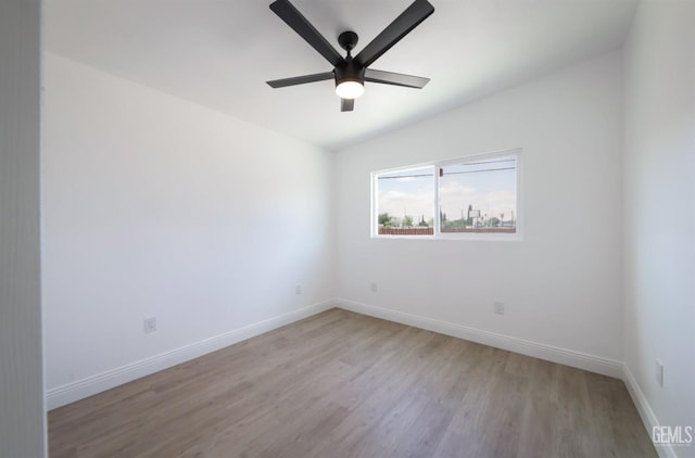 empty room featuring a ceiling fan, baseboards, and light wood-type flooring