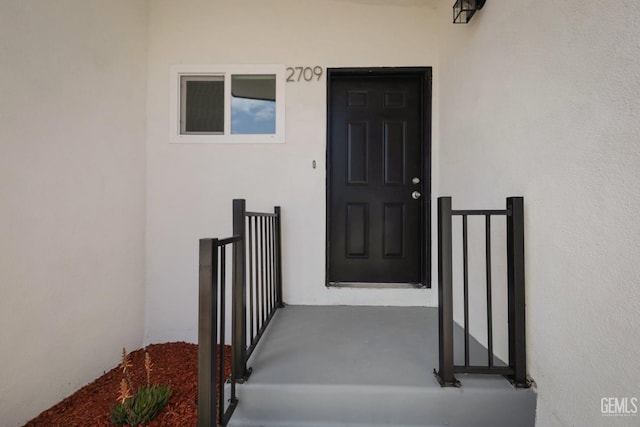 entrance to property featuring stucco siding