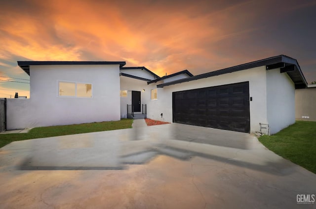 contemporary home with stucco siding, concrete driveway, and an attached garage