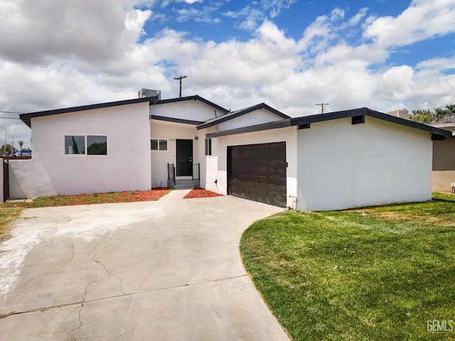 view of front of property featuring a front lawn, stucco siding, concrete driveway, and an attached garage