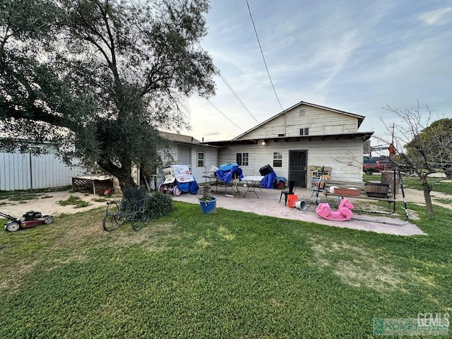 back of property with a yard and a patio area